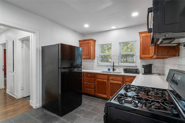 82 Vaughn Dr, Denison, TX 75020 - kitchen with freestanding refrigerator, gas range, light countertops, brown cabinetry, and recessed lighting