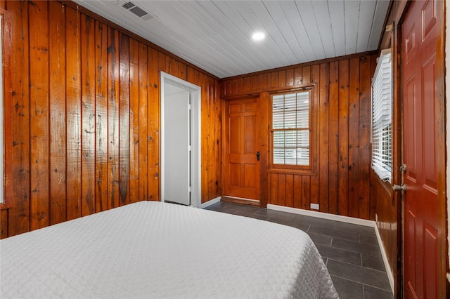 82 Vaughn Dr, Denison, TX 75020 - bedroom with dark tile patterned floors, wood walls, and recessed lighting
