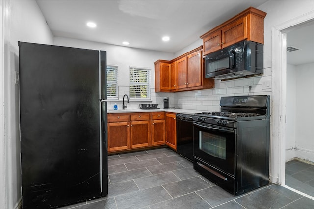 82 Vaughn Dr, Denison, TX 75020 - kitchen featuring black appliances, light countertops, tasteful backsplash, dark tile patterned floors, and brown cabinets