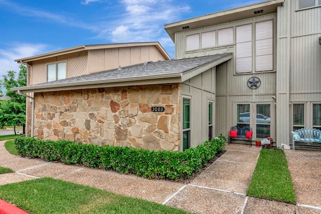 3003 Rustling Leaves Ln, Bedford, TX 76021 - view of side of home with stone siding and roof with shingles