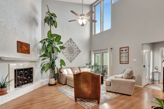 3003 Rustling Leaves Ln, Bedford, TX 76021 - living area featuring wood finished floors, a fireplace, a ceiling fan, and a towering ceiling