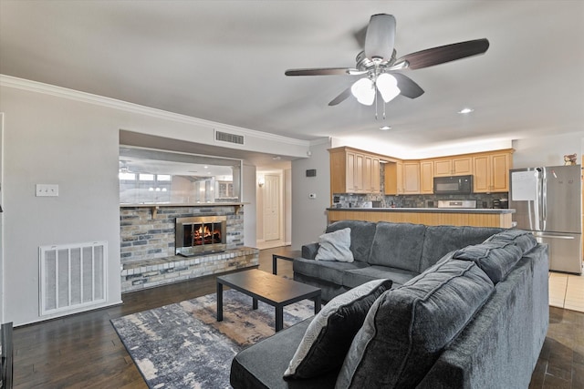 4043 Star Trek Ln, Garland, TX 75044 - living area featuring a ceiling fan, ornamental molding, dark wood-type flooring, a brick fireplace, and recessed lighting