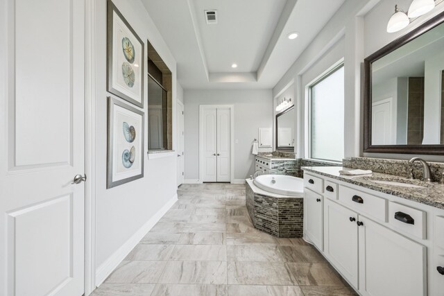 6603 Erin Ln, Parker, TX 75002 - bathroom featuring two vanities, a bath, recessed lighting, and a tray ceiling
