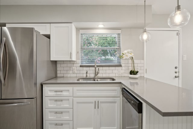 11335 Fernald Ave, Dallas, TX 75218 - kitchen featuring appliances with stainless steel finishes, white cabinetry, decorative backsplash, light countertops, and pendant lighting