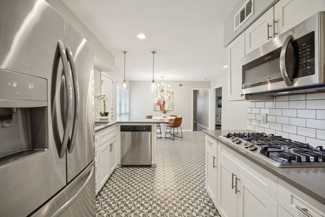 11335 Fernald Ave, Dallas, TX 75218 - kitchen with stainless steel appliances, tasteful backsplash, white cabinets, recessed lighting, and a chandelier