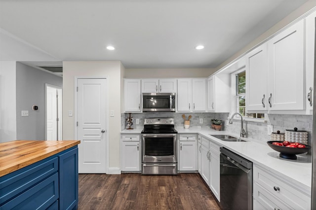 102 Collin Ct, Prosper, TX 75078 - kitchen featuring appliances with stainless steel finishes, tasteful backsplash, white cabinets, dark wood-style flooring, and recessed lighting