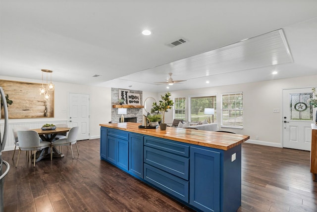 102 Collin Ct, Prosper, TX 75078 - kitchen with wood counters, blue cabinetry, dark wood-style floors, and recessed lighting