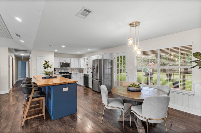 102 Collin Ct, Prosper, TX 75078 - kitchen with stainless steel appliances, wooden counters, dark wood-style floors, recessed lighting, and a wainscoted wall