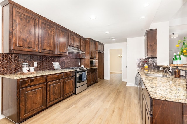 4410 Briargrove Ln, Dallas, TX 75287 - kitchen with stainless steel appliances, under cabinet range hood, light wood-type flooring, decorative backsplash, and light stone counters