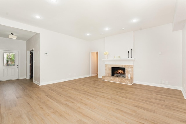 4410 Briargrove Ln, Dallas, TX 75287 - unfurnished living room featuring light wood-style floors, recessed lighting, and a lit fireplace
