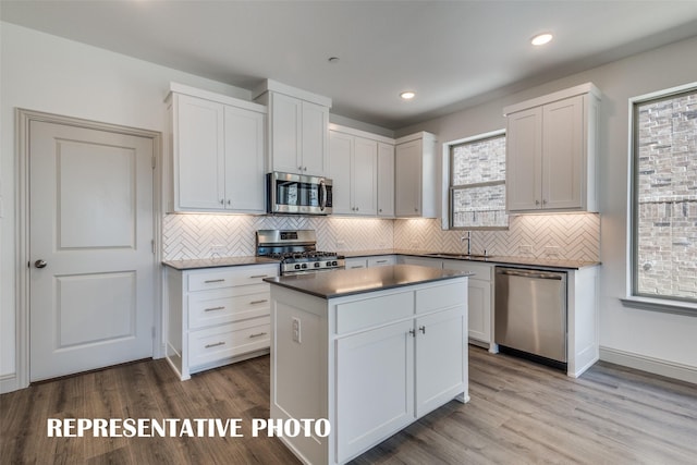 736 4th St, Argyle, TX 76226 - kitchen featuring stainless steel appliances, dark countertops, decorative backsplash, wood finished floors, and recessed lighting