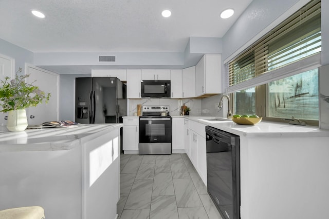 1024 E Peters Colony Rd, Carrollton, TX 75007 - kitchen featuring black appliances, light marble finish flooring, light countertops, white cabinetry, and recessed lighting
