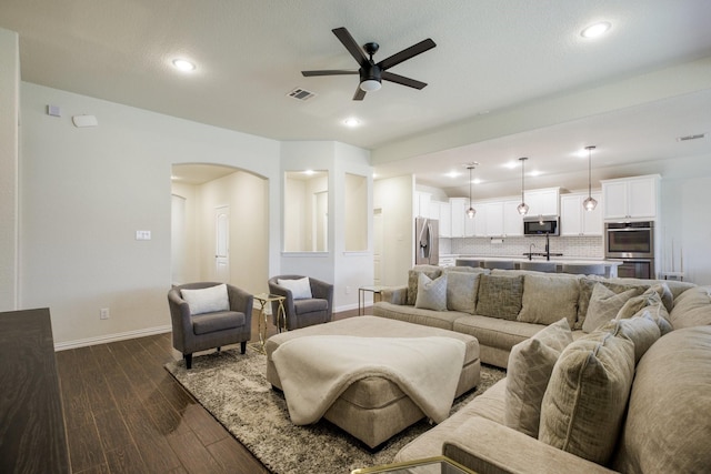 8116 Charford Dr, Fort Worth, TX 76131 - living room with arched walkways, a ceiling fan, dark wood-type flooring, and recessed lighting