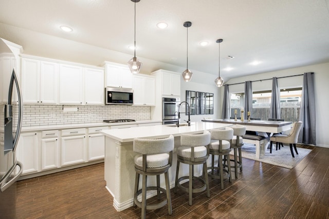 8116 Charford Dr, Fort Worth, TX 76131 - kitchen with stainless steel appliances, decorative backsplash, dark wood-style flooring, an island with sink, and light countertops
