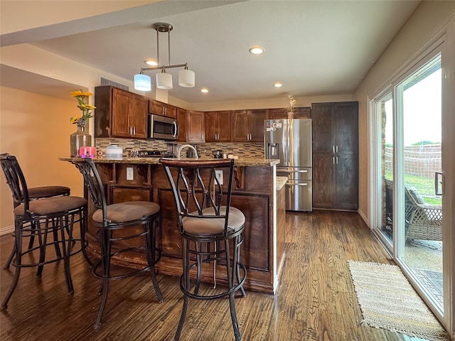 503 White Oak St, Allen, TX 75002 - kitchen with appliances with stainless steel finishes, dark wood-style floors, backsplash, light stone countertops, and recessed lighting