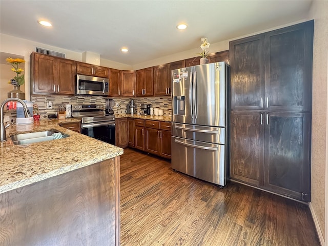 503 White Oak St, Allen, TX 75002 - kitchen with appliances with stainless steel finishes, dark wood-style flooring, light stone countertops, backsplash, and recessed lighting