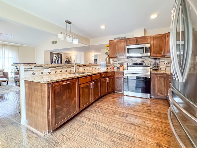 503 White Oak St, Allen, TX 75002 - kitchen featuring appliances with stainless steel finishes, a peninsula, light wood-style flooring, backsplash, and lofted ceiling