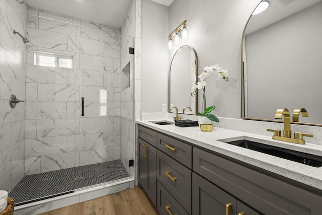 6311 Pebble Ave, Dallas, TX 75217 - bathroom with double vanity, a marble finish shower, and wood finished floors