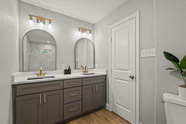6311 Pebble Ave, Dallas, TX 75217 - bathroom featuring double vanity, wood finished floors, and a shower