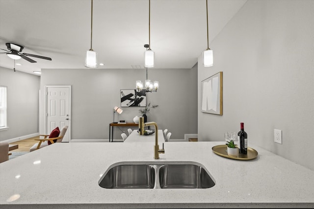 6311 Pebble Ave, Dallas, TX 75217 - kitchen with a ceiling fan, open floor plan, light stone counters, and hanging light fixtures