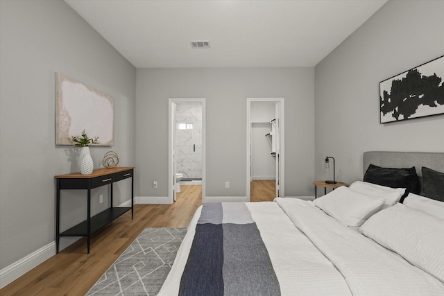 6311 Pebble Ave, Dallas, TX 75217 - bedroom with wood finished floors, a walk in closet, and connected bathroom