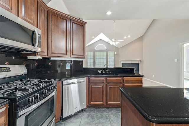 3212 Cantura Dr, Mesquite, TX 75181 - kitchen featuring appliances with stainless steel finishes, ceiling fan, decorative backsplash, lofted ceiling, and a fireplace
