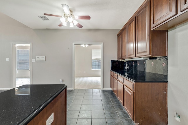3212 Cantura Dr, Mesquite, TX 75181 - kitchen with a ceiling fan, decorative backsplash, tile patterned floors, and dark stone countertops