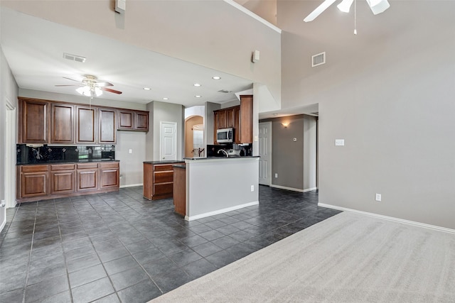 3212 Cantura Dr, Mesquite, TX 75181 - kitchen featuring ceiling fan, stainless steel microwave, dark countertops, arched walkways, and recessed lighting