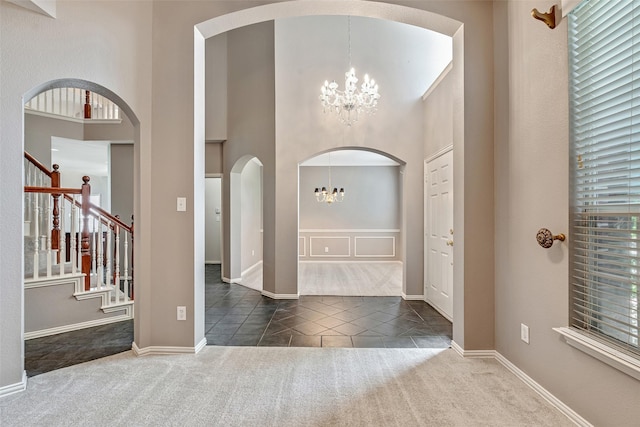 3212 Cantura Dr, Mesquite, TX 75181 - carpeted entrance foyer with a chandelier, a towering ceiling, stairs, arched walkways, and tile patterned flooring