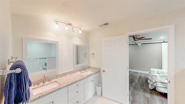 2305 Briarwood Ln, Carrollton, TX 75006 - bathroom with double vanity, wood finished floors, and a ceiling fan