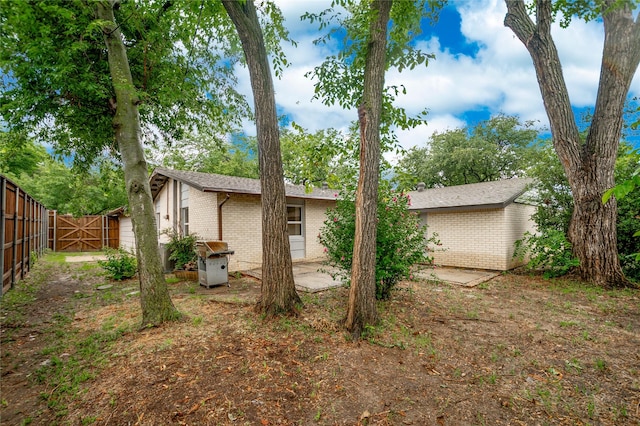 2305 Briarwood Ln, Carrollton, TX 75006 - back of house with brick siding, a patio area, and a gate