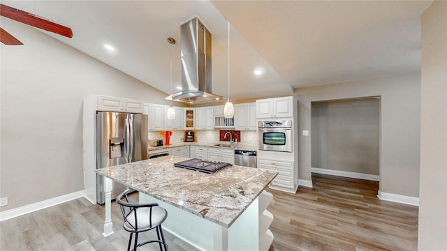 2305 Briarwood Ln, Carrollton, TX 75006 - kitchen with appliances with stainless steel finishes, wall chimney exhaust hood, light stone countertops, a breakfast bar, and a kitchen island