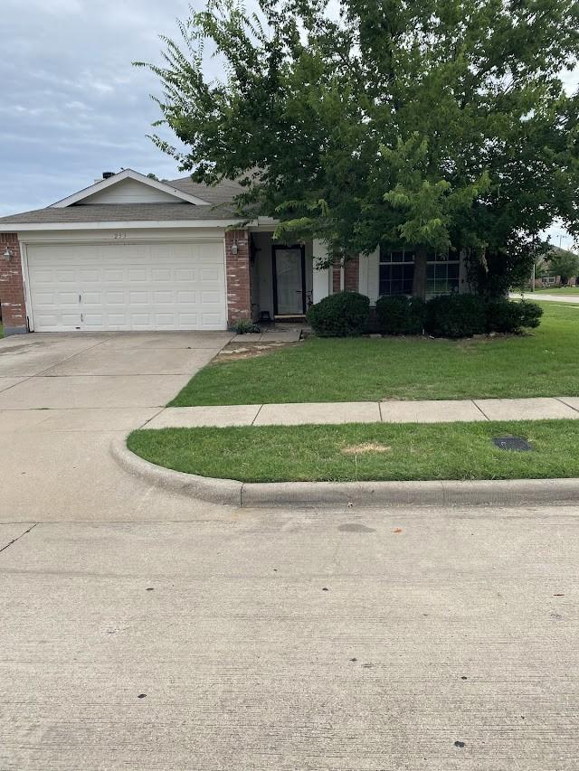 253 Pine Crest Dr, Justin, TX 76247 - view of front facade with brick siding, an attached garage, driveway, and a front yard