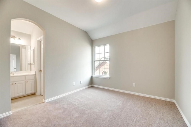9204 Bottlebrush Ln, Irving, TX 75063 - unfurnished bedroom with light carpet, arched walkways, vaulted ceiling, and ensuite bath