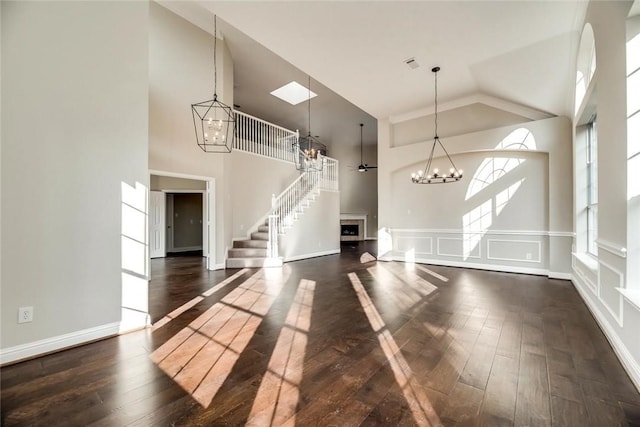 9204 Bottlebrush Ln, Irving, TX 75063 - foyer with a chandelier, high vaulted ceiling, wood-type flooring, stairway, and a fireplace