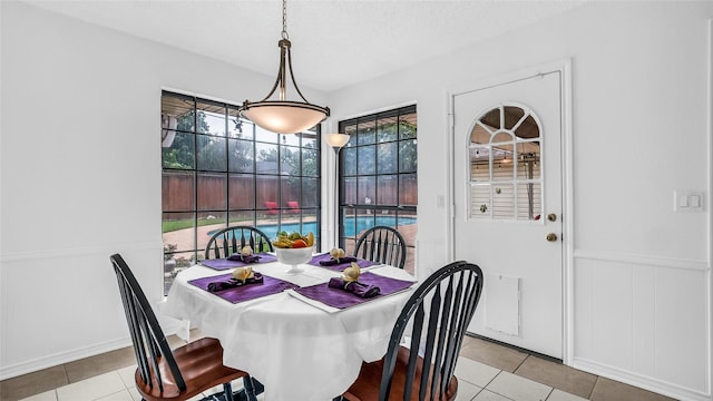 3705 Starlight Trl, Plano, TX 75023 - tiled dining room with a decorative wall, wainscoting, and a textured ceiling