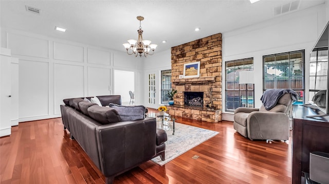 3705 Starlight Trl, Plano, TX 75023 - living area with a decorative wall, a chandelier, wood finished floors, a fireplace, and recessed lighting
