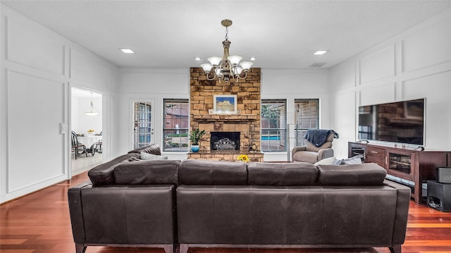 3705 Starlight Trl, Plano, TX 75023 - living area featuring a fireplace, a chandelier, wood finished floors, healthy amount of natural light, and a decorative wall