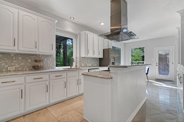 7955 Enclave Way, Dallas, TX 75218 - kitchen featuring island range hood, stainless steel fridge with ice dispenser, a center island, tasteful backsplash, and white cabinets