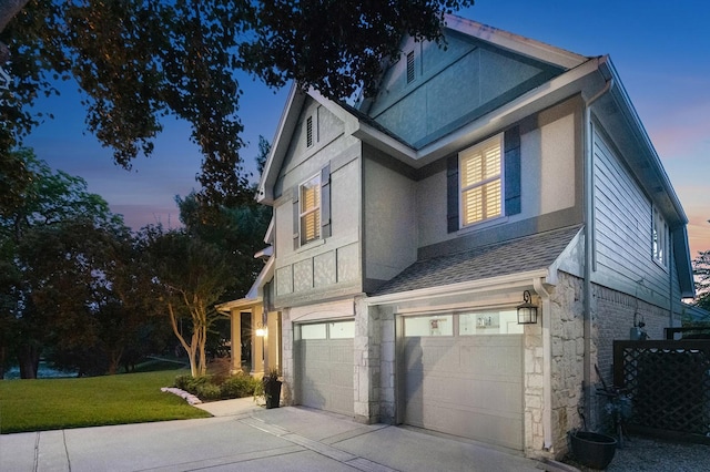 7955 Enclave Way, Dallas, TX 75218 - view of property exterior featuring an attached garage, stucco siding, driveway, a lawn, and stone siding