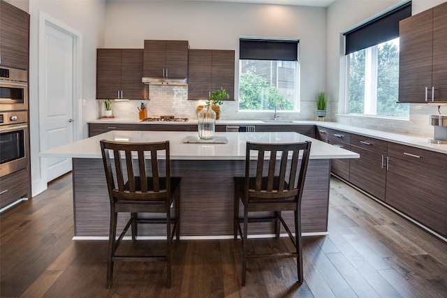 381 E Greenbriar Ln Unit 501, Dallas, TX 75203 - kitchen with a kitchen breakfast bar, modern cabinets, light countertops, and a kitchen island