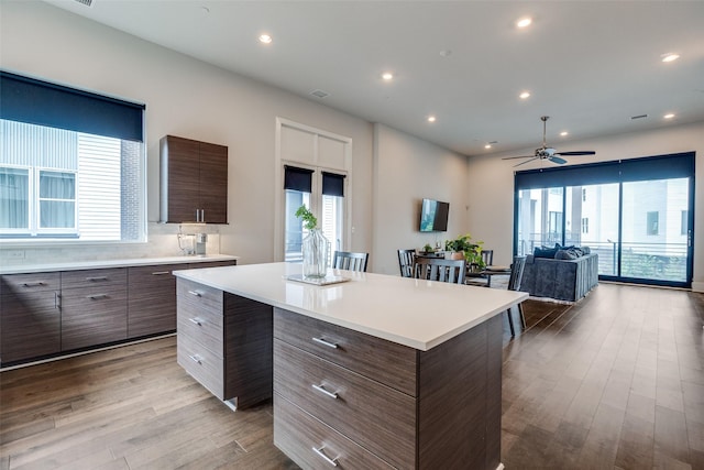 381 E Greenbriar Ln Unit 501, Dallas, TX 75203 - kitchen with modern cabinets, light countertops, wood finished floors, a center island, and recessed lighting