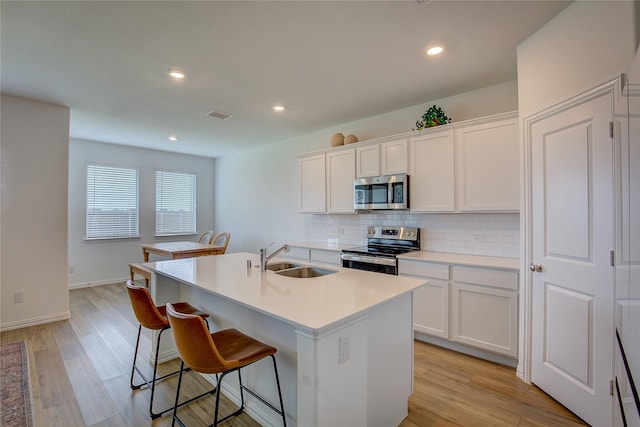 5221 Rockrose Ln, Princeton, TX 75407 - kitchen with stainless steel appliances, tasteful backsplash, a kitchen bar, an island with sink, and white cabinets