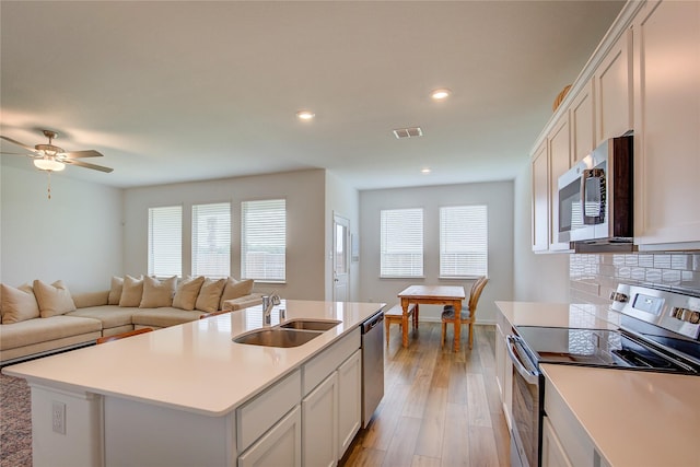 5221 Rockrose Ln, Princeton, TX 75407 - kitchen with stainless steel appliances, open floor plan, light wood-style floors, recessed lighting, and backsplash