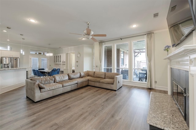 5729 Ridgehaven Dr, Plano, TX 75093 - living area with a tile fireplace, ceiling fan, light wood-type flooring, recessed lighting, and ornamental molding