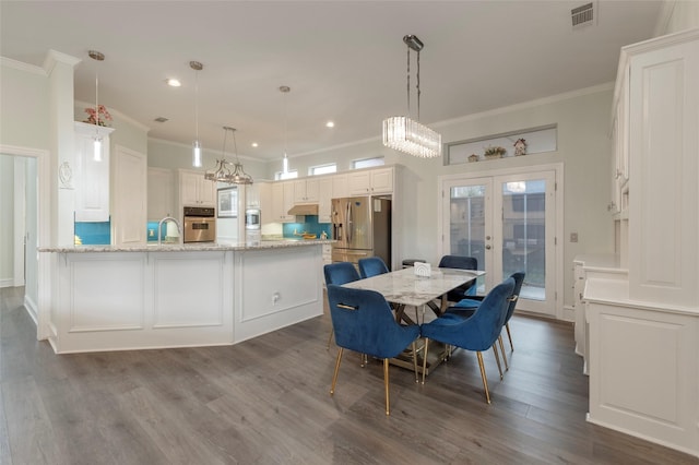 5729 Ridgehaven Dr, Plano, TX 75093 - dining space with crown molding, french doors, a chandelier, dark wood-type flooring, and recessed lighting