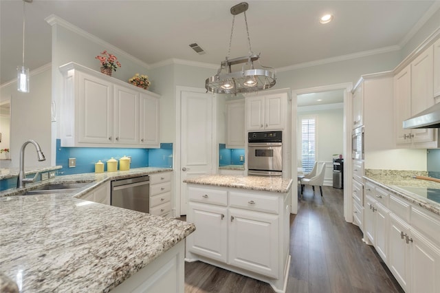 5729 Ridgehaven Dr, Plano, TX 75093 - kitchen with stainless steel appliances, white cabinets, dark wood-type flooring, crown molding, and a center island