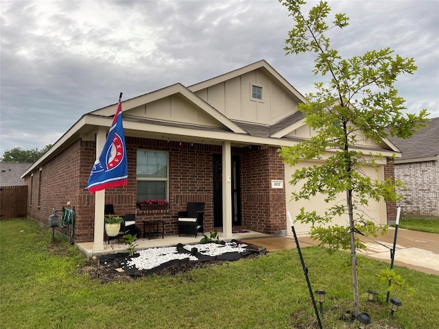 803 Odlozil Ln, Ennis, TX 75119 - view of front of home with brick siding, board and batten siding, an attached garage, concrete driveway, and covered porch