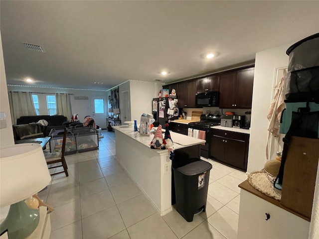 803 Odlozil Ln, Ennis, TX 75119 - kitchen featuring black appliances, light countertops, light tile patterned flooring, dark brown cabinets, and recessed lighting