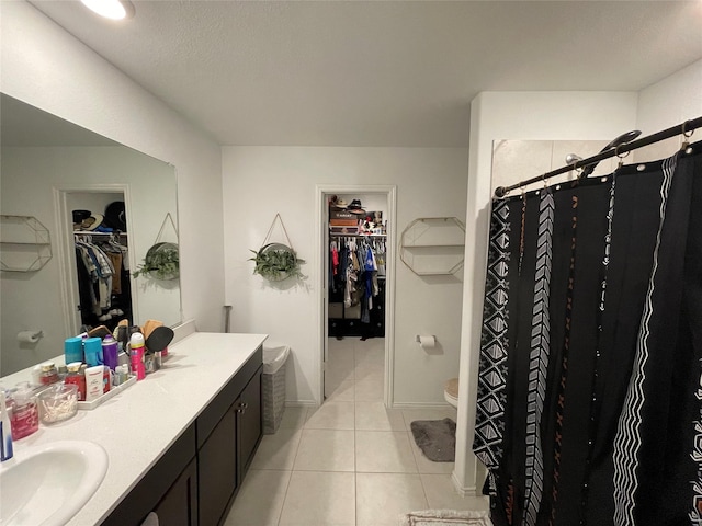 803 Odlozil Ln, Ennis, TX 75119 - bathroom with a walk in closet, vanity, tile patterned floors, and curtained shower